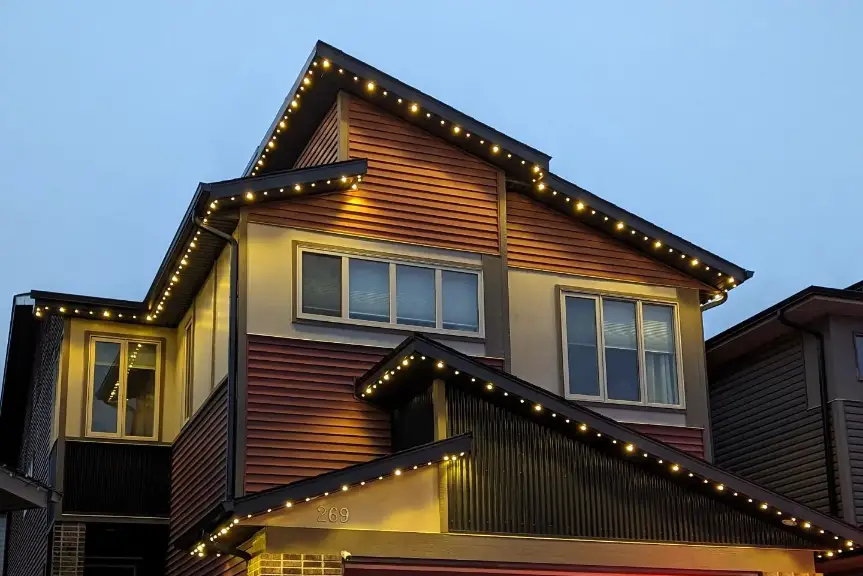 Permanent LED track lighting glowing along the roofline of a Calgary home at dusk